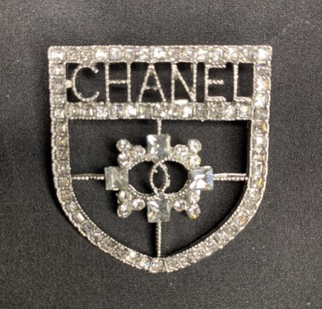 CHANEL Silver Badge Brooch - Opulent Fashion